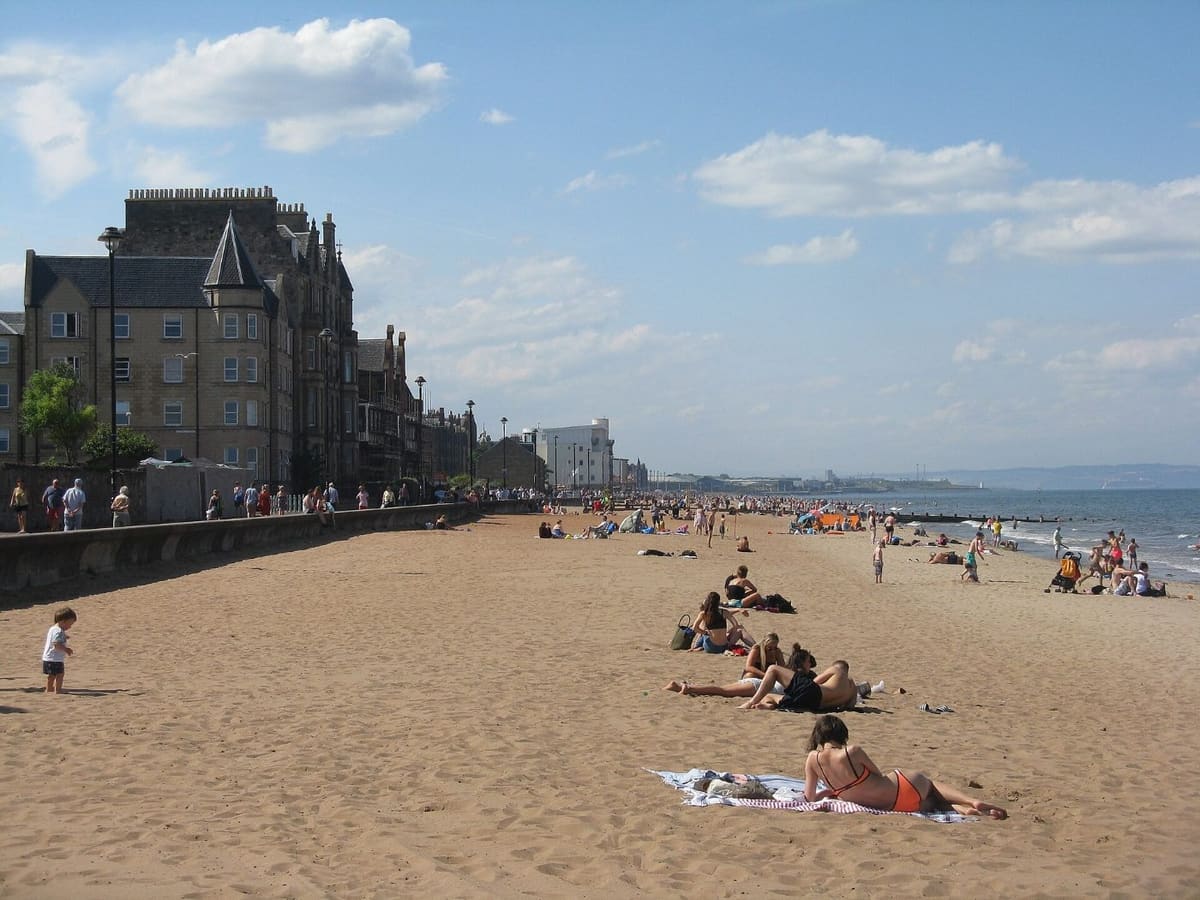 Sunbathers on the sandy beach and promenade at Portobello, Edinburgh
