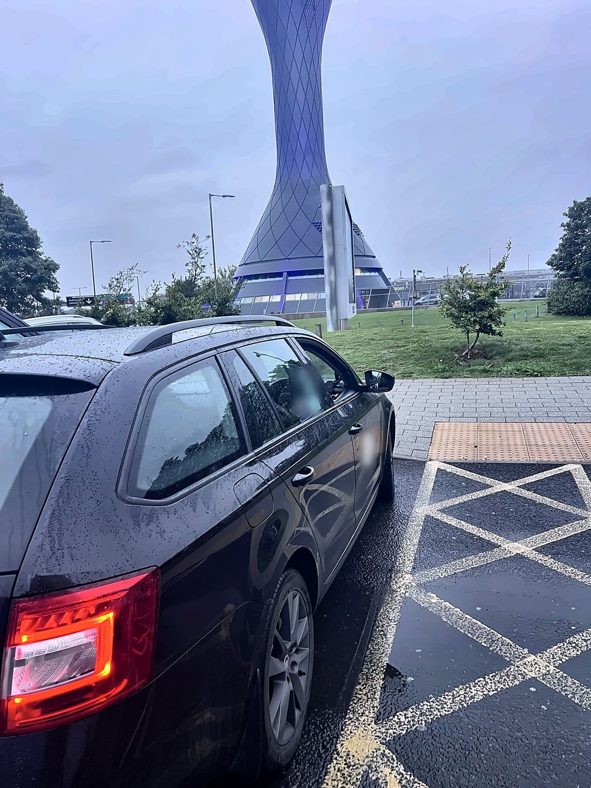 RTransfer black Skoda Octavia estate parked by the Edinburgh Airport control tower, ready for a pre-booked pickup